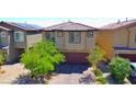 Two-story home with tile roof, brick paved driveway, desert landscaping, and solar panels on neighboring home at 8324 S Miller Ln, Las Vegas, NV 89113
