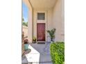 Inviting front entrance with a solid wood door, desert landscaping and stone accents at 9013 Meisenheimer Ave, Las Vegas, NV 89143