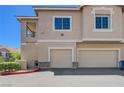 Exterior view of townhomes with garages, showing the architecture and neutral color scheme at 9901 Trailwood Dr # 2109, Las Vegas, NV 89134