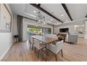 Open-concept dining area with wood beams, modern lighting, and seamless access to outdoor living space at 10084 Terrastone Dr, Las Vegas, NV 89148