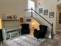 Elegant living room with piano, plush chairs, and decorative staircase at 10754 Balmoral St, Las Vegas, NV 89141