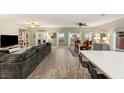 Spacious living room with hardwood floors, large sofa and adjacent dining area at 10754 Balmoral St, Las Vegas, NV 89141