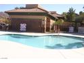 Community swimming pool surrounded by a black iron safety fence and lounge area at 1158 Gecko Rd, Henderson, NV 89002
