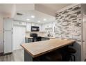 Kitchen with wood floors, white cabinets and accent tile at 1316 Driscoll Dr # 201, Las Vegas, NV 89128