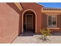 Inviting front entrance with arched doorway, a stone walkway, and colorful, drought-tolerant landscaping at 1424 Pin Cushion Rdg, Mesquite, NV 89034