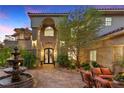 Beautiful home featuring a water fountain, elegant double doors, and lush landscaping at 17 Grand Corniche Dr, Henderson, NV 89011