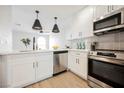 Bright kitchen features stainless steel appliances, white cabinets, and pendant lighting at 1800 Edmond St # 115, Las Vegas, NV 89146