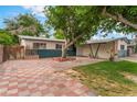 Spacious front yard with unique tile patio and lush green lawn surrounding a mature tree at 1904 Fontenelle St, Las Vegas, NV 89102