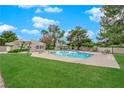 Community pool with lush green lawn, lounge chairs, and manicured landscaping at 2007 Cutlass Dr # 0, Henderson, NV 89014