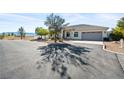 Single-story home with a large driveway and desert landscaping at 2500 S Zephyr Ave, Pahrump, NV 89048