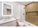 Modern bathroom with a glass enclosed shower, wood accent wall, and stylish fixtures at 2536 Herrod Dr, North Las Vegas, NV 89030