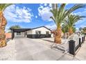 Charming single-story home featuring a covered carport, white fence, and well-maintained landscaping at 2536 Herrod Dr, North Las Vegas, NV 89030