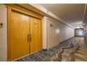 Long hallway with neutral colors and patterned carpet leading to unit entrance at 3111 Bel Air Dr # 18B, Las Vegas, NV 89109