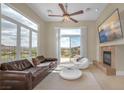 Inviting living room with large windows and scenic views, complemented by a cozy fireplace and modern furnishings at 32 Cerchio Basso, Henderson, NV 89011