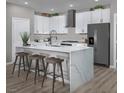 Modern kitchen with white cabinets, stainless steel appliances, and an island with seating at 3434 Oristano Ln, Henderson, NV 89044