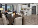 Open-concept living room and kitchen area with hardwood floors and large windows at 3434 Oristano Ln, Henderson, NV 89044