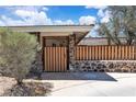 Charming single-story home featuring a wooden fence atop a stone wall and lush landscaping at 3845 S Torrey Pines Dr, Las Vegas, NV 89103