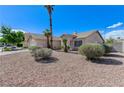 View of a single Gathering home with rock landscaping, palm trees, and a well manicured yard at 444 Flores Cir, Las Vegas, NV 89123