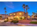 Charming two-story home with well-manicured landscaping, mature palm trees, and a circular driveway at 4471 Borrego Springs Way, Las Vegas, NV 89129