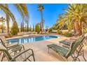 Inviting backyard pool featuring lounge chairs and lush tropical landscaping at 4471 Borrego Springs Way, Las Vegas, NV 89129