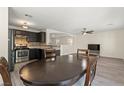 Bright dining area featuring luxury vinyl plank flooring, dark cabinets, stainless appliances, and stylish light fixtures at 4846 Lone Grove Dr, Las Vegas, NV 89139