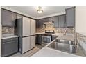 Bright kitchen with dark cabinets, stainless steel appliances, grey countertops and stylish backsplash at 4846 Lone Grove Dr, Las Vegas, NV 89139