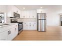Modern kitchen boasts stainless steel appliances, white cabinetry, and light wood flooring at 4848 Fuentes Cir, Las Vegas, NV 89121