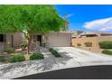 Charming two-story home with desert landscaping, green tree and covered front porch at 5631 Hill Cliff Ct, North Las Vegas, NV 89031