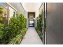Modern entryway with garden view and luxurious stone pathway leading to a glass door at 6194 Stone Rise St, Las Vegas, NV 89135
