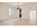 Bright dining room featuring neutral tile flooring, chandelier, and a view into the kitchen at 632 Cadence Vista Dr, Henderson, NV 89011