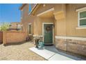 Inviting front entrance with a green door, decorative wreath, and charming stone accents and desert landscaping at 6409 Dundock Ave, Las Vegas, NV 89122
