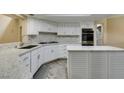 Updated kitchen featuring white cabinetry, stone countertops, and stainless steel appliances at 7217 Mission Hills Dr, Las Vegas, NV 89113