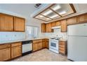 Functional kitchen with wood cabinets, white appliances, and ample counter space at 725 Weatherstone Dr, Las Vegas, NV 89110