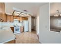 Well-lit kitchen with wood cabinetry and white appliances at 725 Weatherstone Dr, Las Vegas, NV 89110