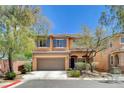 Two-story home featuring a neutral color scheme, a two car garage, and manicured landscaping at 10220 Adobe Mountain St, Las Vegas, NV 89178