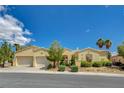 Stunning exterior elevation of this home with well-manicured landscaping, a three car garage, and lovely curb appeal at 10562 Cerotto Ln, Las Vegas, NV 89135