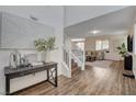 Inviting entryway with wood floors, staircase, modern console table and open access to living area at 1114 Junipine Ave, North Las Vegas, NV 89081