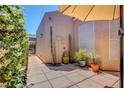 Desert patio with stone pavers, shade umbrella, desert landscaping, and privacy wall at 130 Twin Towers Ave, Las Vegas, NV 89123