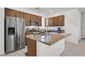 Charming kitchen with stainless steel refrigerator, wooden cabinets, and a granite countertop island at 1388 Graphite Ave, Henderson, NV 89002