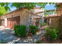 Charming townhome entrance with private garage, lush landscaping, and wrought iron gate at 2486 Sabado St, Las Vegas, NV 89121
