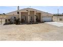 Inviting single-story home with covered porch, two-car garage, and desert surroundings at 2571 N David St, Pahrump, NV 89060