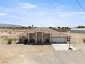 Single-story desert home with covered entry, 2-car garage, and a spacious, level lot at 2571 N David St, Pahrump, NV 89060