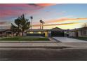 Charming single-story home featuring a putting green and modern garage door at dusk at 2909 Gilmary Ave, Las Vegas, NV 89102
