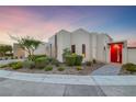 Modern home featuring a red door and desert-style landscaping with shrubs and decorative rock at 383 Solitude Peak Ln, Henderson, NV 89012