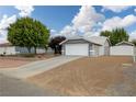 Home with a long driveway, two-car garage, and landscaped front yard, offering a welcoming curb appeal at 5200 Wheatland Dr, Pahrump, NV 89061