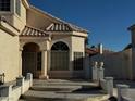 Welcoming front entryway with elegant stucco columns, arched window and decorative iron gate on side at 529 Rancho Del Mar Way, North Las Vegas, NV 89031