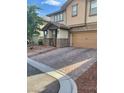 Two-story home with a paved driveway, two-car garage, and manicured landscaping at 5627 Spanish Valor Rd, Las Vegas, NV 89135