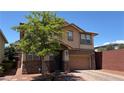 Attractive two-story home with a two-car garage, neat landscaping, and a brick-paved driveway at 5627 Spanish Valor Rd, Las Vegas, NV 89135