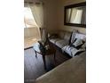 Relax in this comfy living room featuring wood floors, a plush sofa, and access to a balcony with great views at 5710 E Tropicana Ave # 1053, Las Vegas, NV 89122