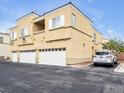Exterior view of a residential building with garages, private balcony and parking at 6324 Desert Leaf St # 3, North Las Vegas, NV 89081